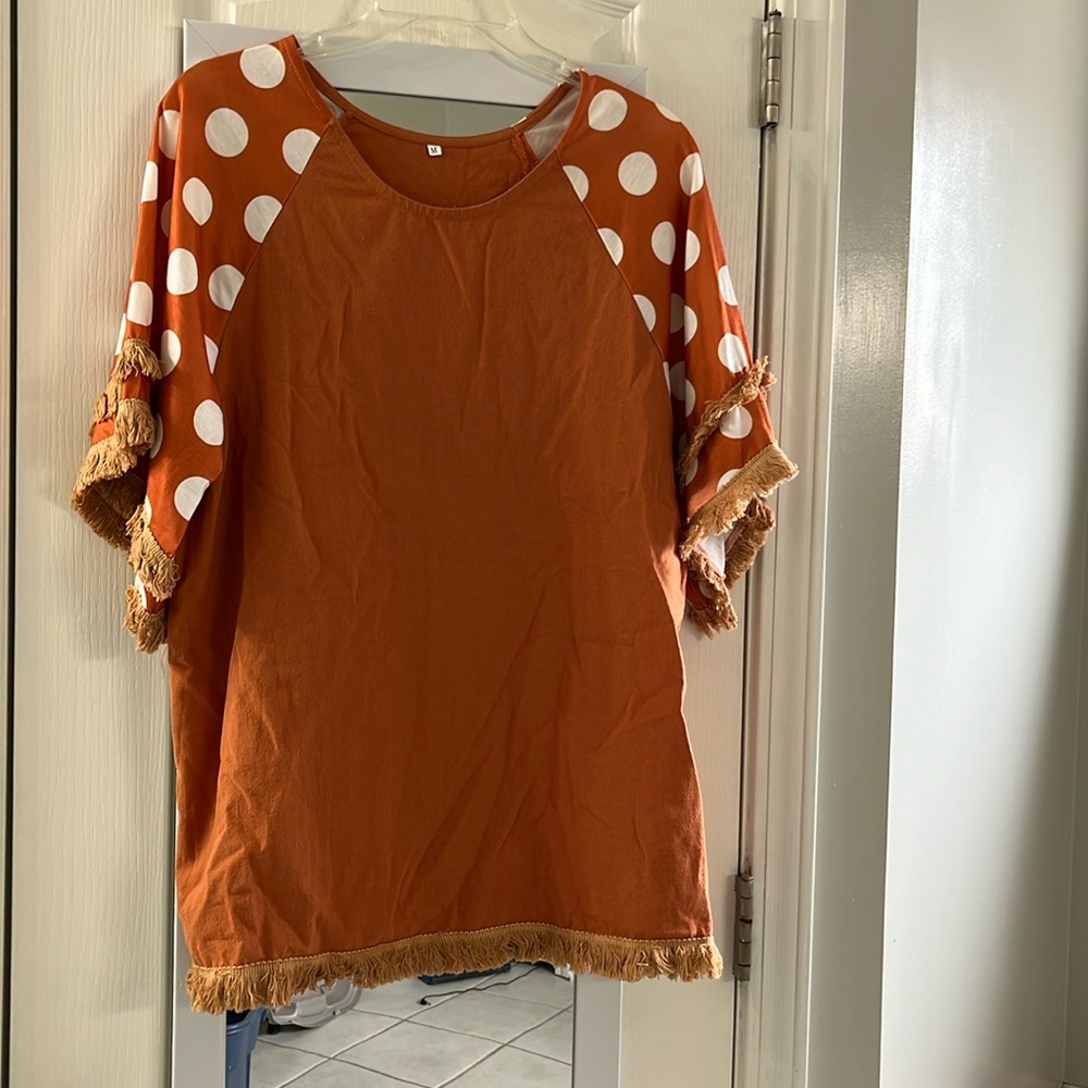 Women’s short sleeve top. Burnt orange.  Polka dot sleeves.  Size medium.